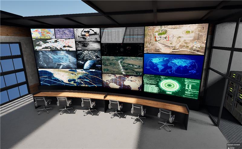 A modern control room with a long desk, six chairs, and a large video wall displaying maps, data, and surveillance images.