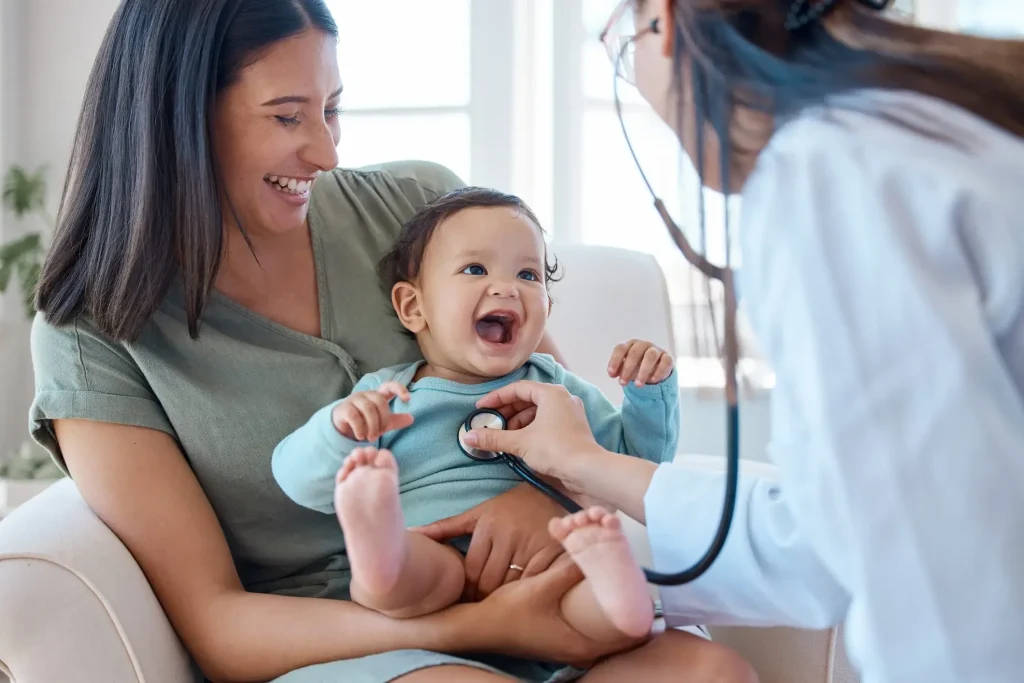 A baby is being examined by a doctor with a stethoscope.