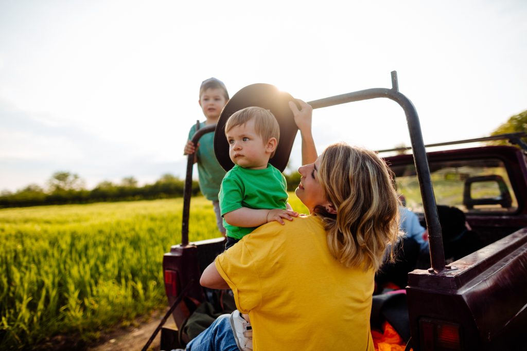 Photo d'une jeune famille dans leur camionnette à la ferme.